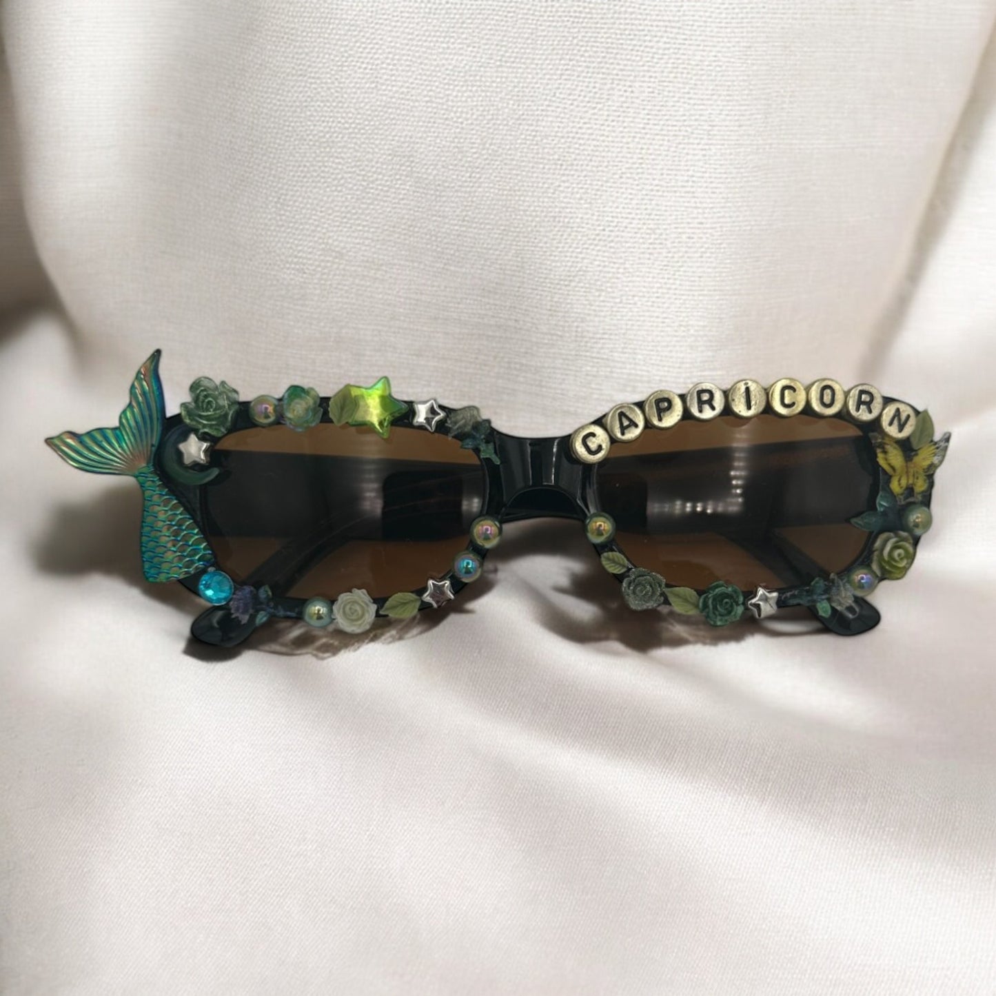 Black sunglasses that say Capricorn