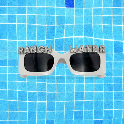Sunglasses with 'RANCH WATER' text on a blue tiled background