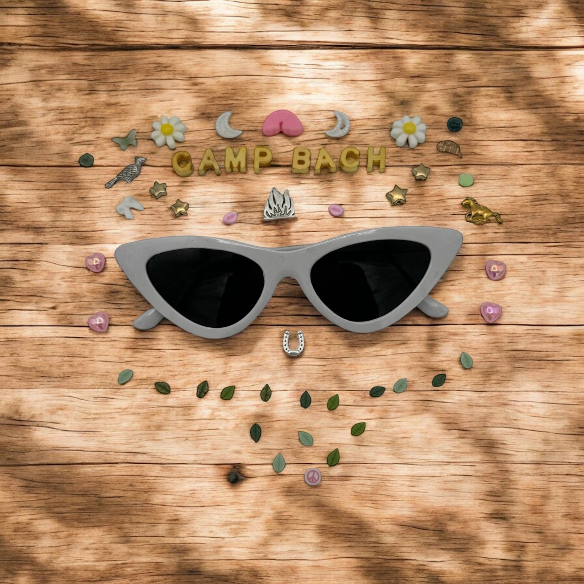 white cat eye sunglasses shown with charms around the frames