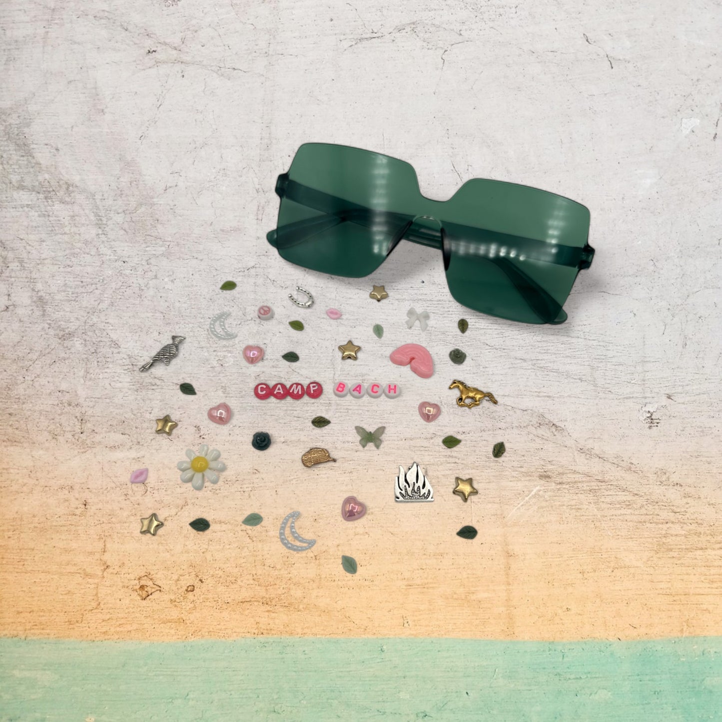 green square sunglasses shown with charms around the frames