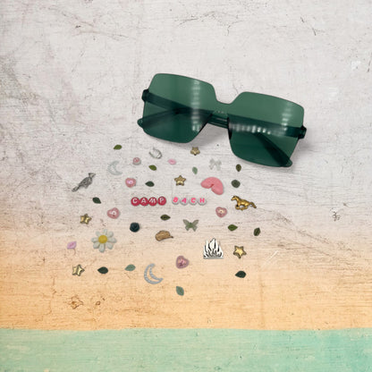 green square sunglasses shown with charms around the frames