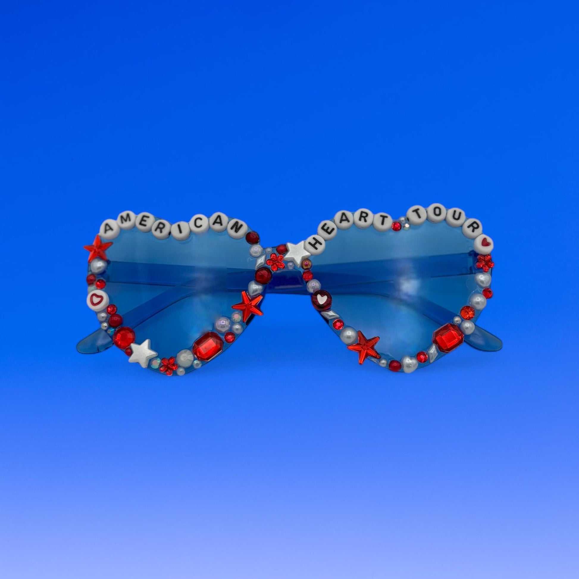 Sunglasses with decorative beads and letters on a blue background