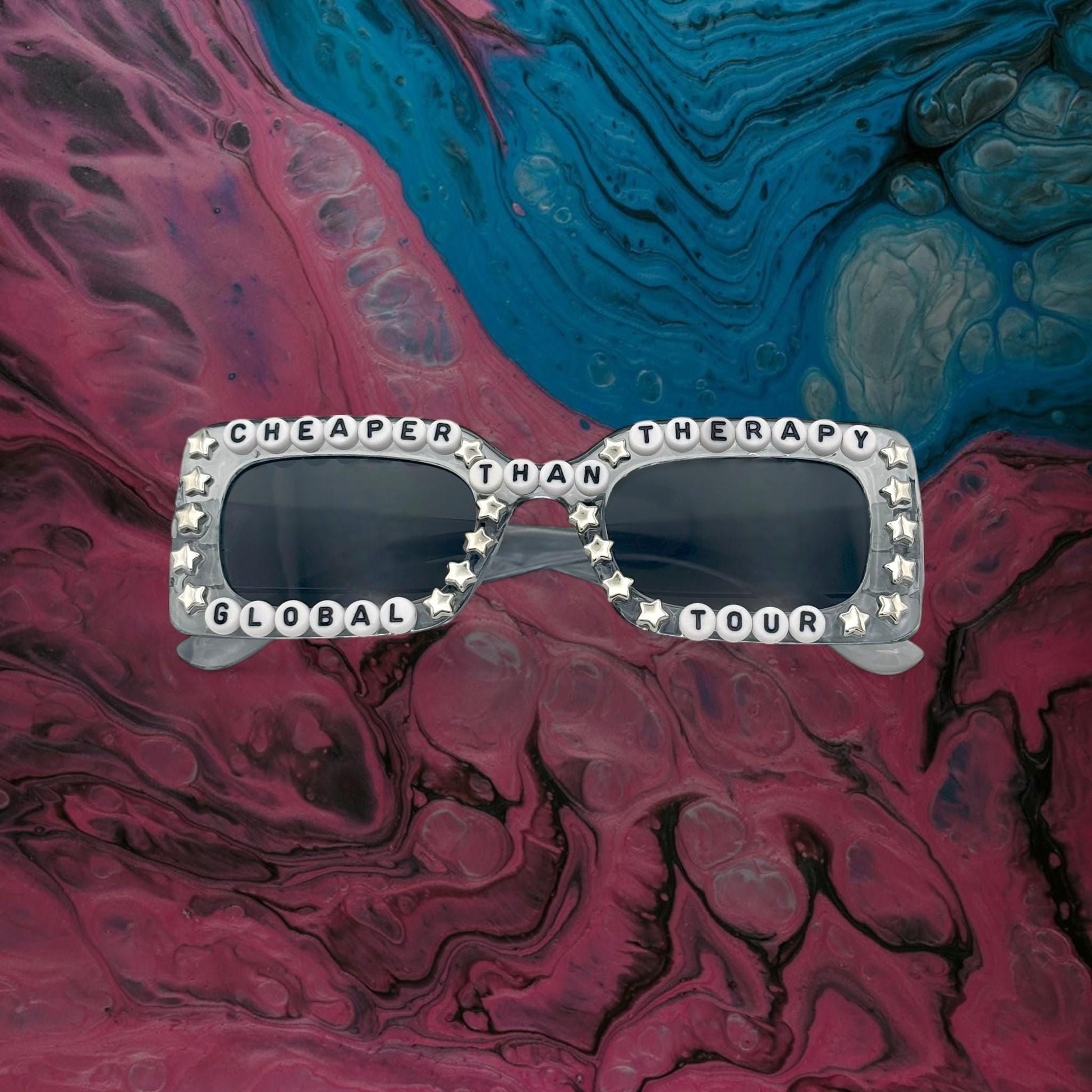 Gray concert sunglasses with “Cheaper Than Therapy” text