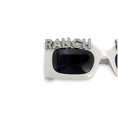 Sunglasses with 'RANCH' embellishment on a white background