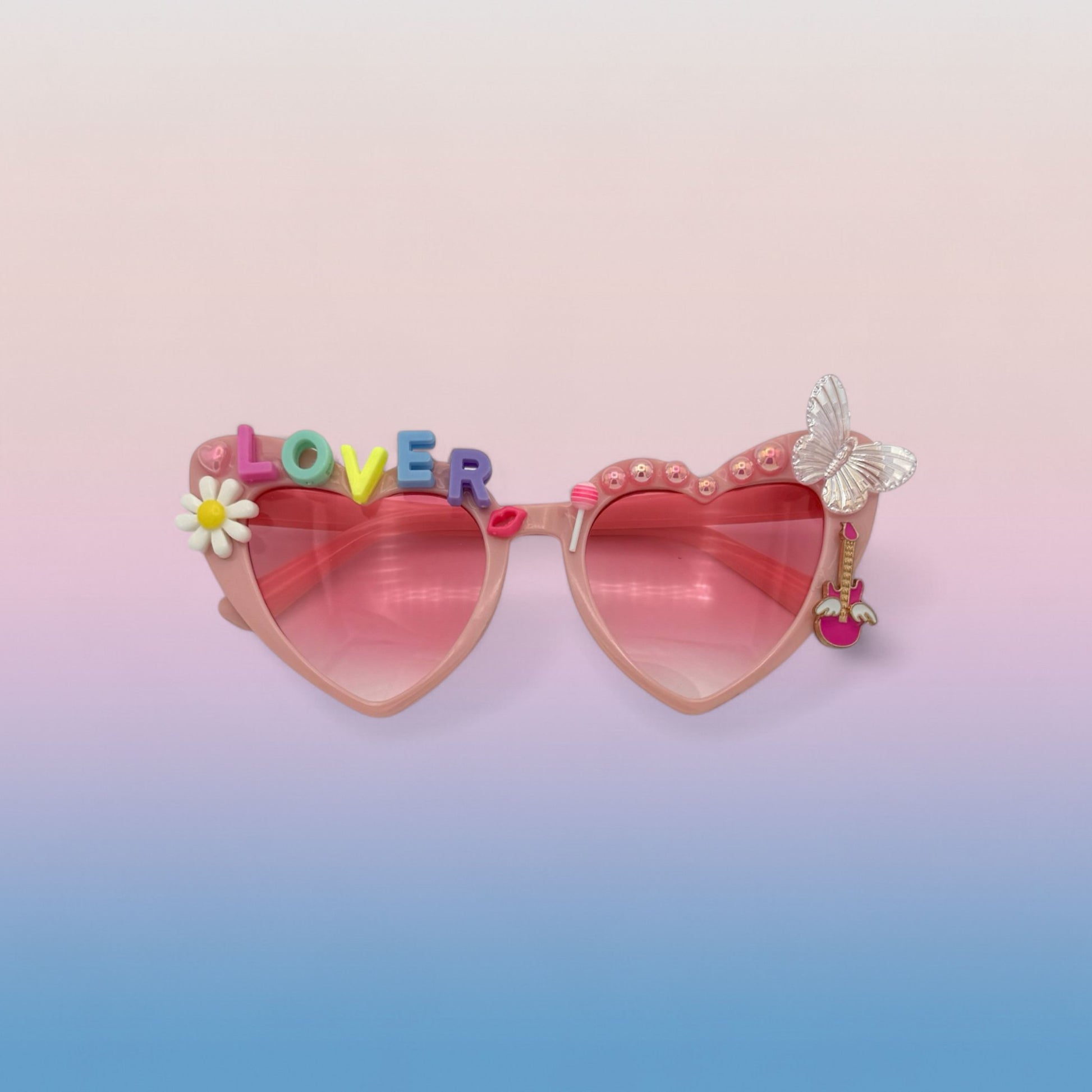 Pink heart sunglasses that have pastel charms and letters