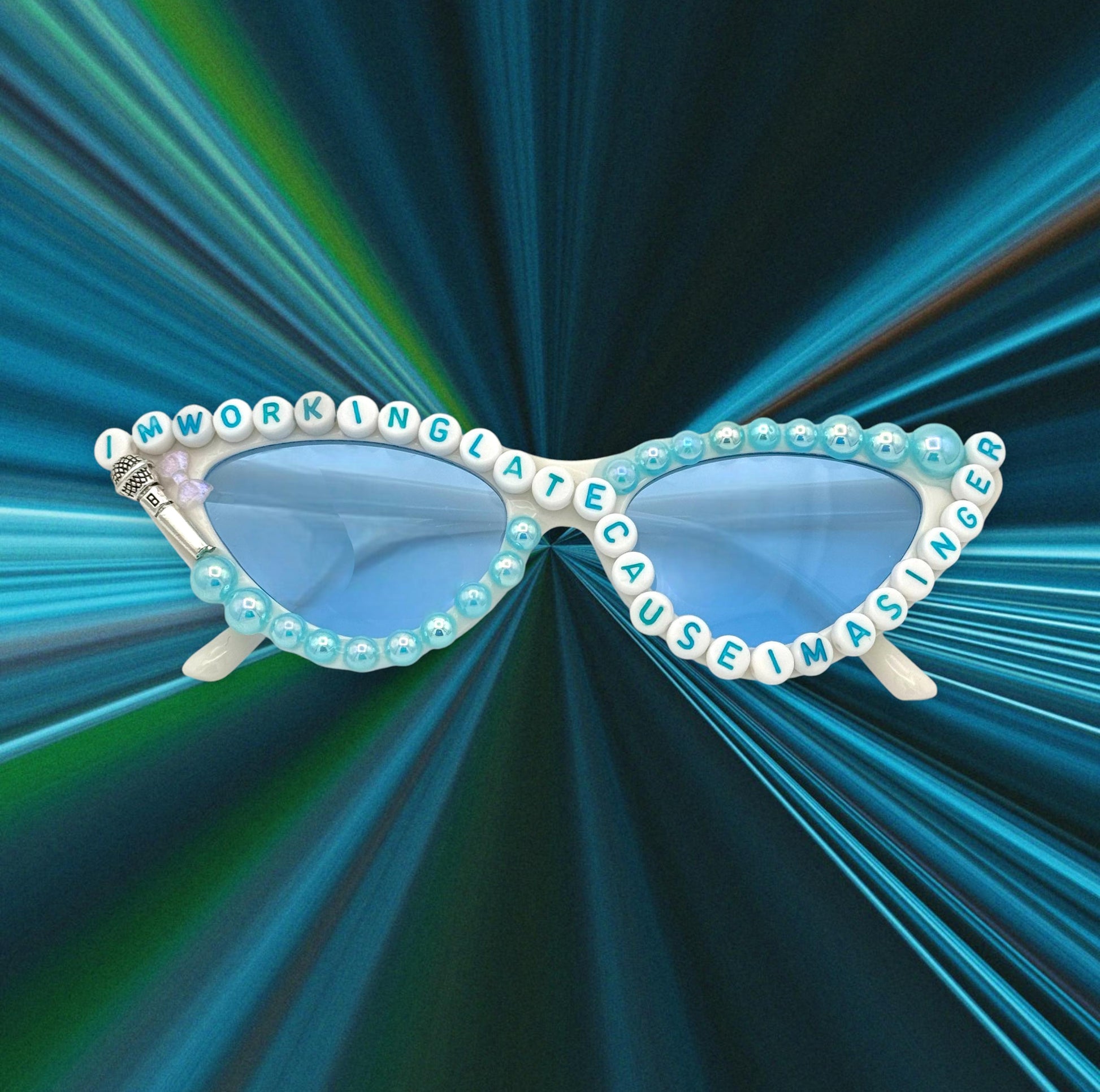 White cat-eye sunglasses with blue pearls and lyric text on top